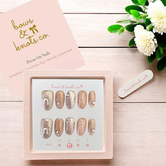 Press-on nails set with a pink box and floral decoration on a wooden surface
