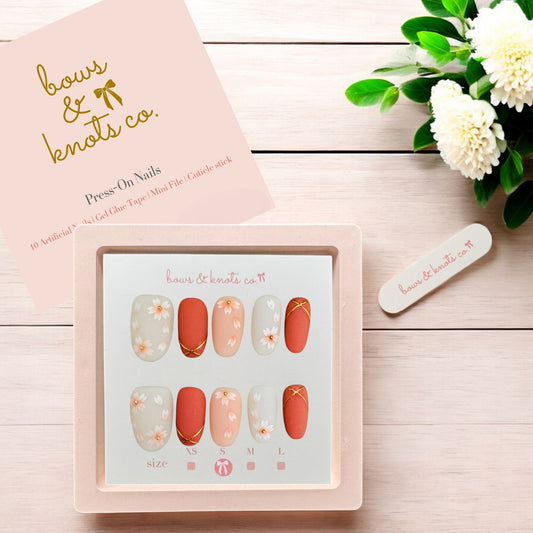 Set of press-on nails with a display card on a wooden surface, featuring the brand 'bows & knots co'.