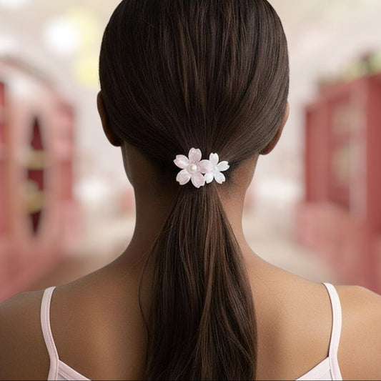 Woman with a ponytail holding a white flower hair accessory, blurred background