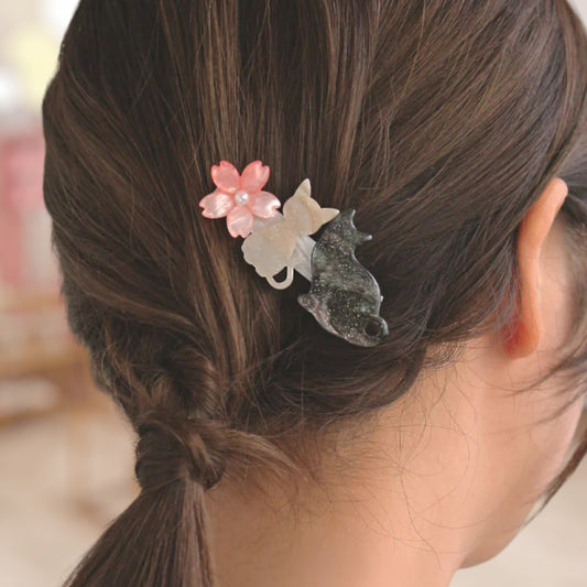 Decorative hair clip with floral and star design on a person's hair.