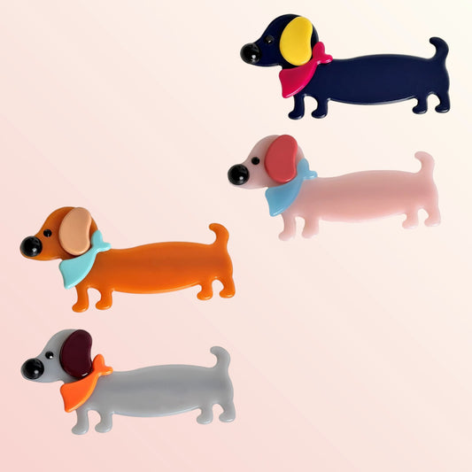 Four colorful little dog hair clips on a light pink background