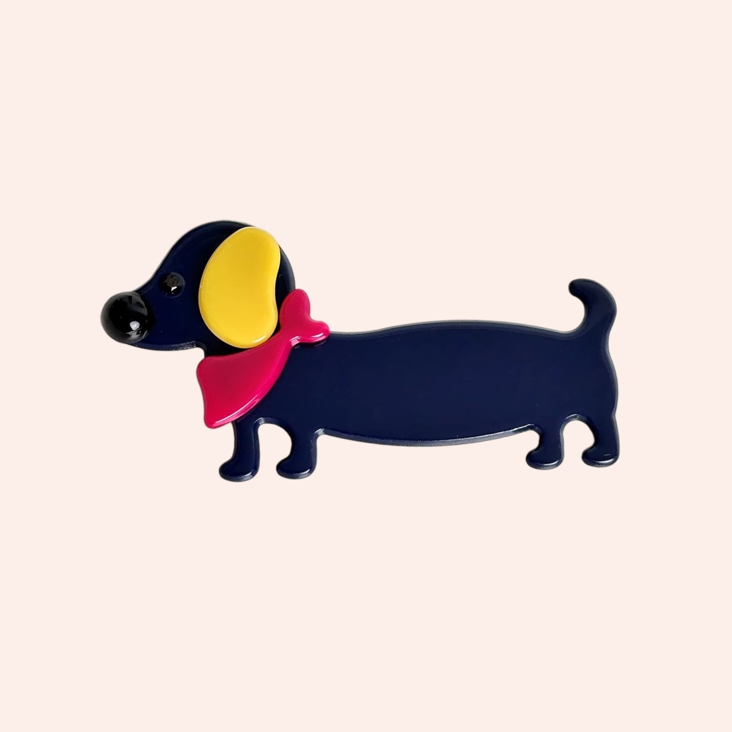 Colorful dog-shaped hair clip on a beige background