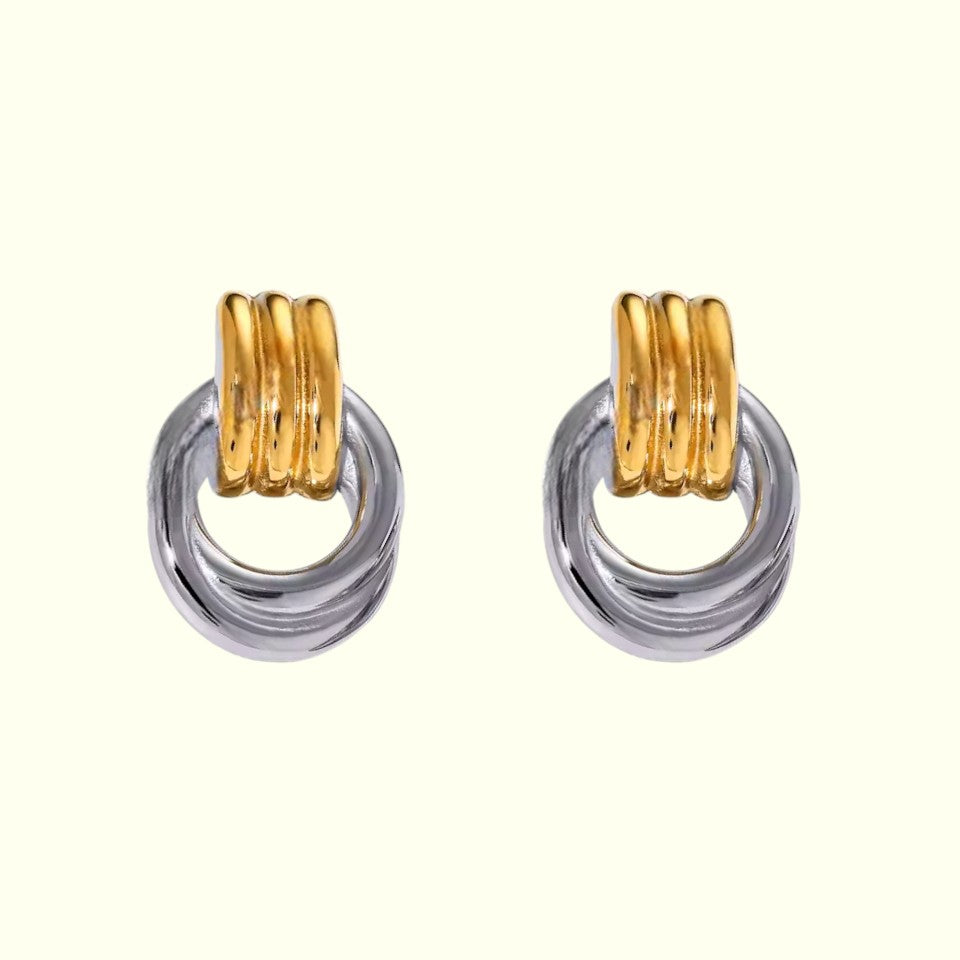 Pair of earrings with gold and silver rings on a white background