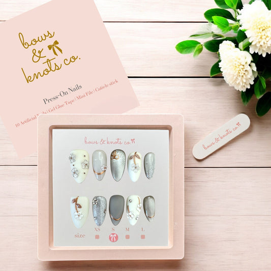 Press-on nails set with a pink box and floral decoration on a wooden surface