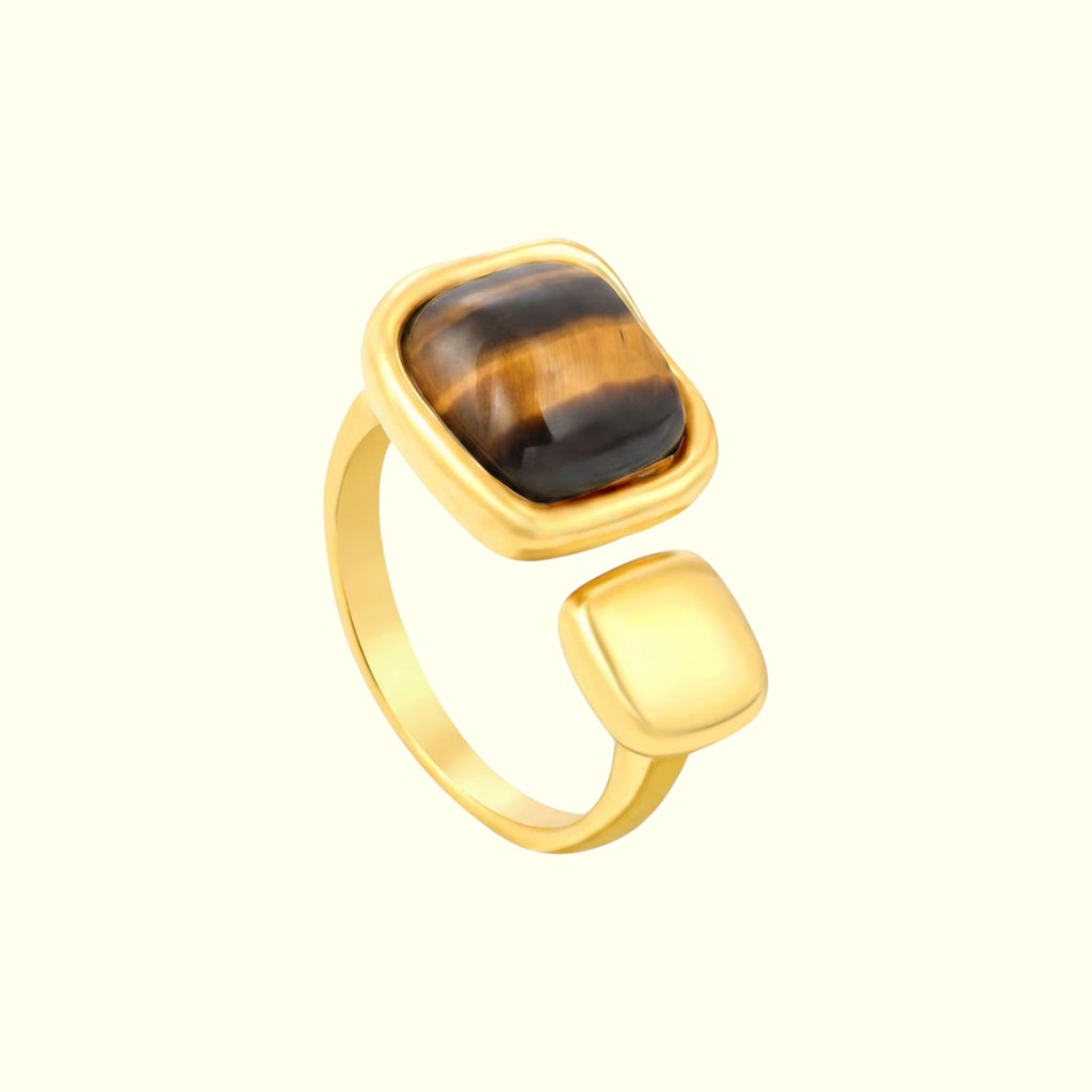 Gold ring with a tiger's eye stone on a white background