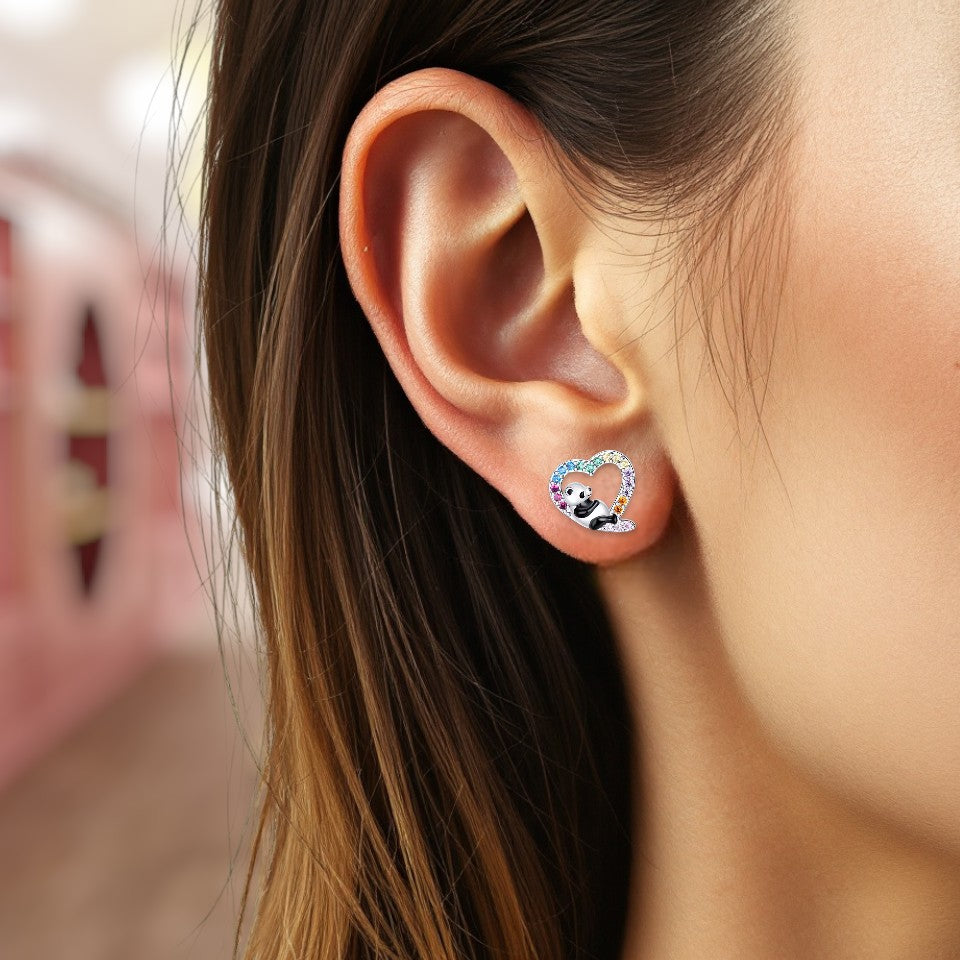 Close-up of an ear wearing a panda-themed earring with a blurred background