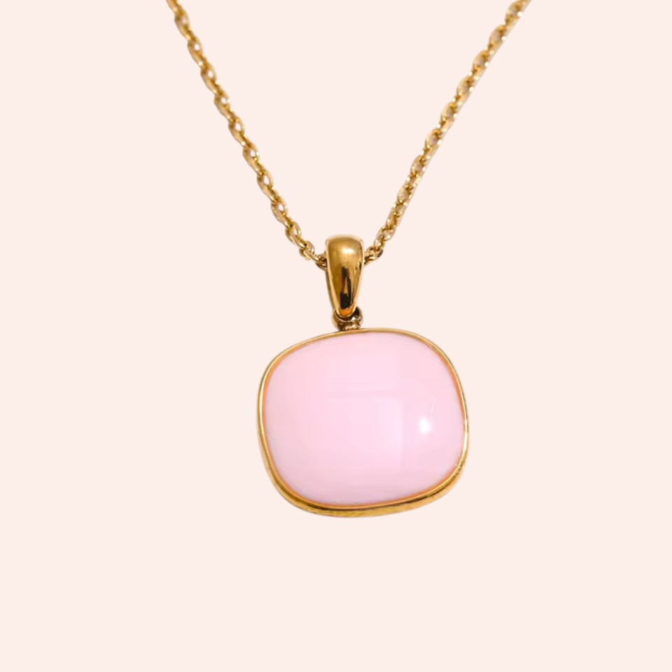 Necklace with a pink pendant on a light beige background