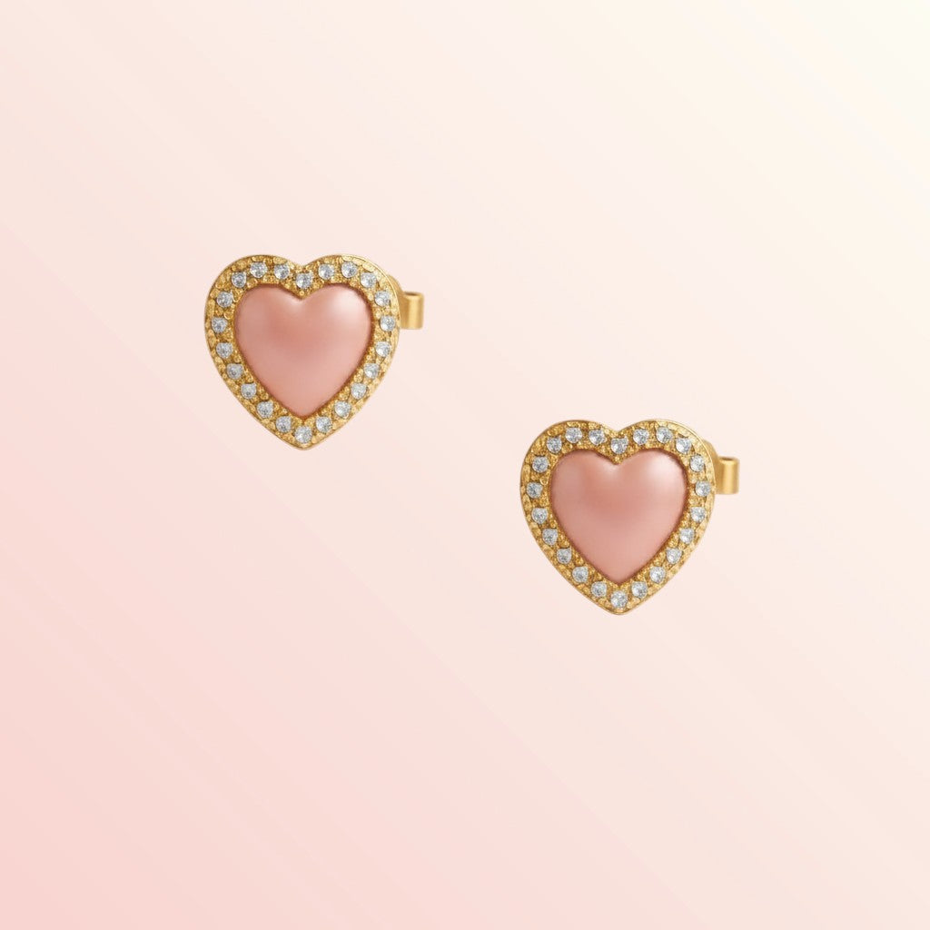 Heart-shaped earrings with pink centers and gold borders on a light pink background