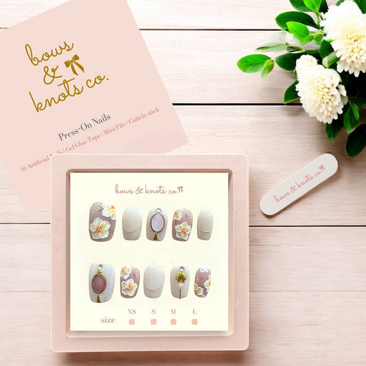 Press-on nails set with a display card and floral decoration on a wooden surface.