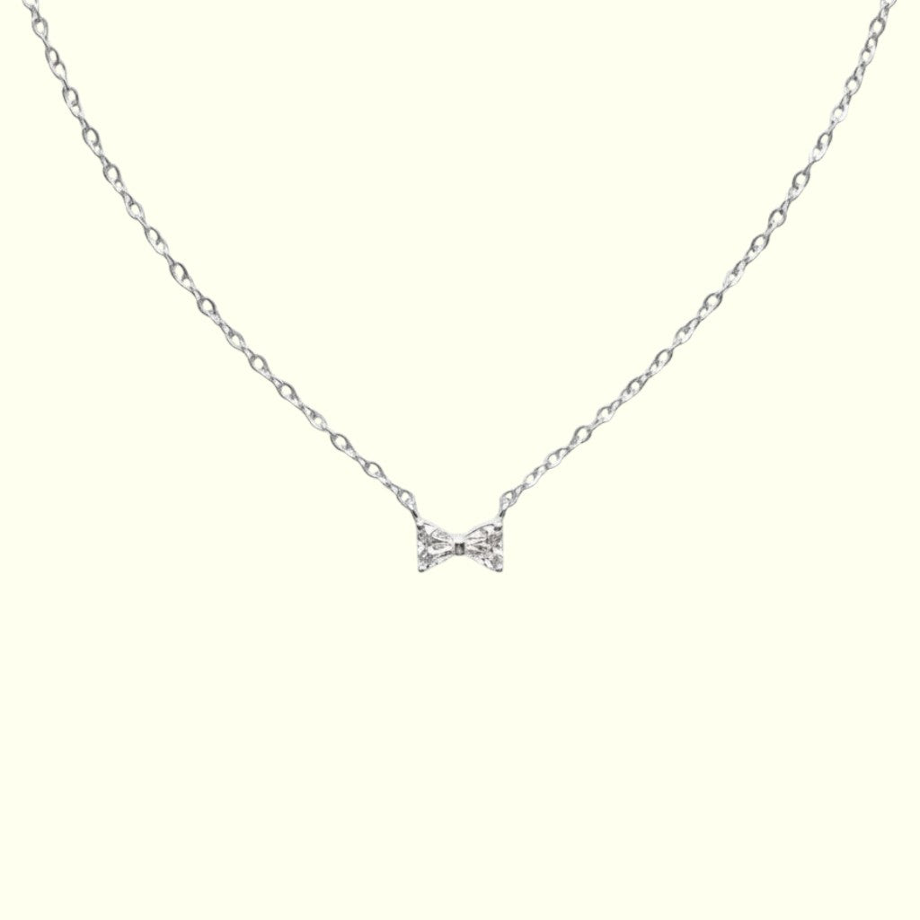 Silver bow-shaped necklace on a white background