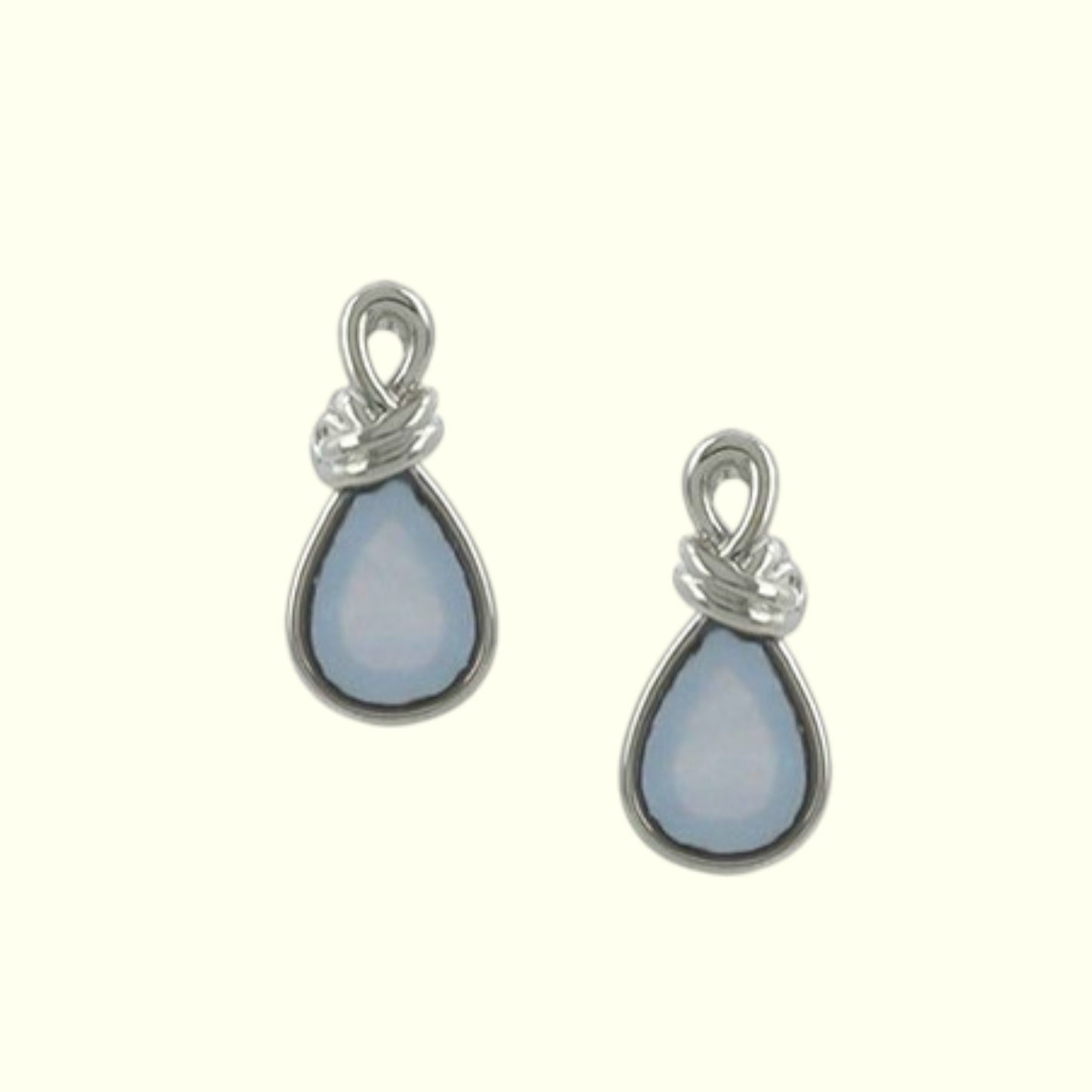 Pair of silver teardrop earrings with light blue stones on a white background