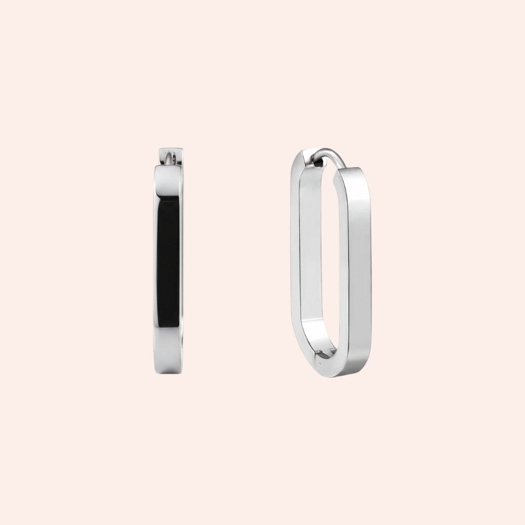 Silver hoop earrings on a light pink background