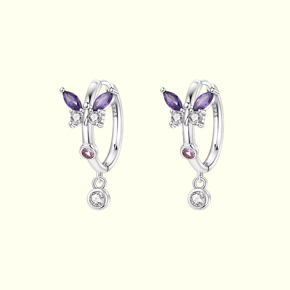 Pair of silver earrings with purple and pink gemstones on a white background