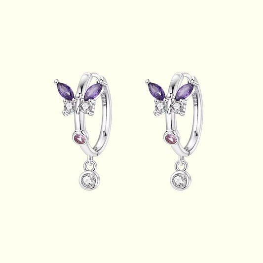 Pair of silver earrings with purple and pink gemstones on a white background