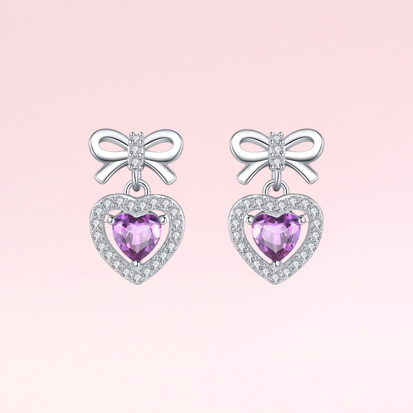 Pair of earrings with heart-shaped purple gemstones and bow designs on a pink background