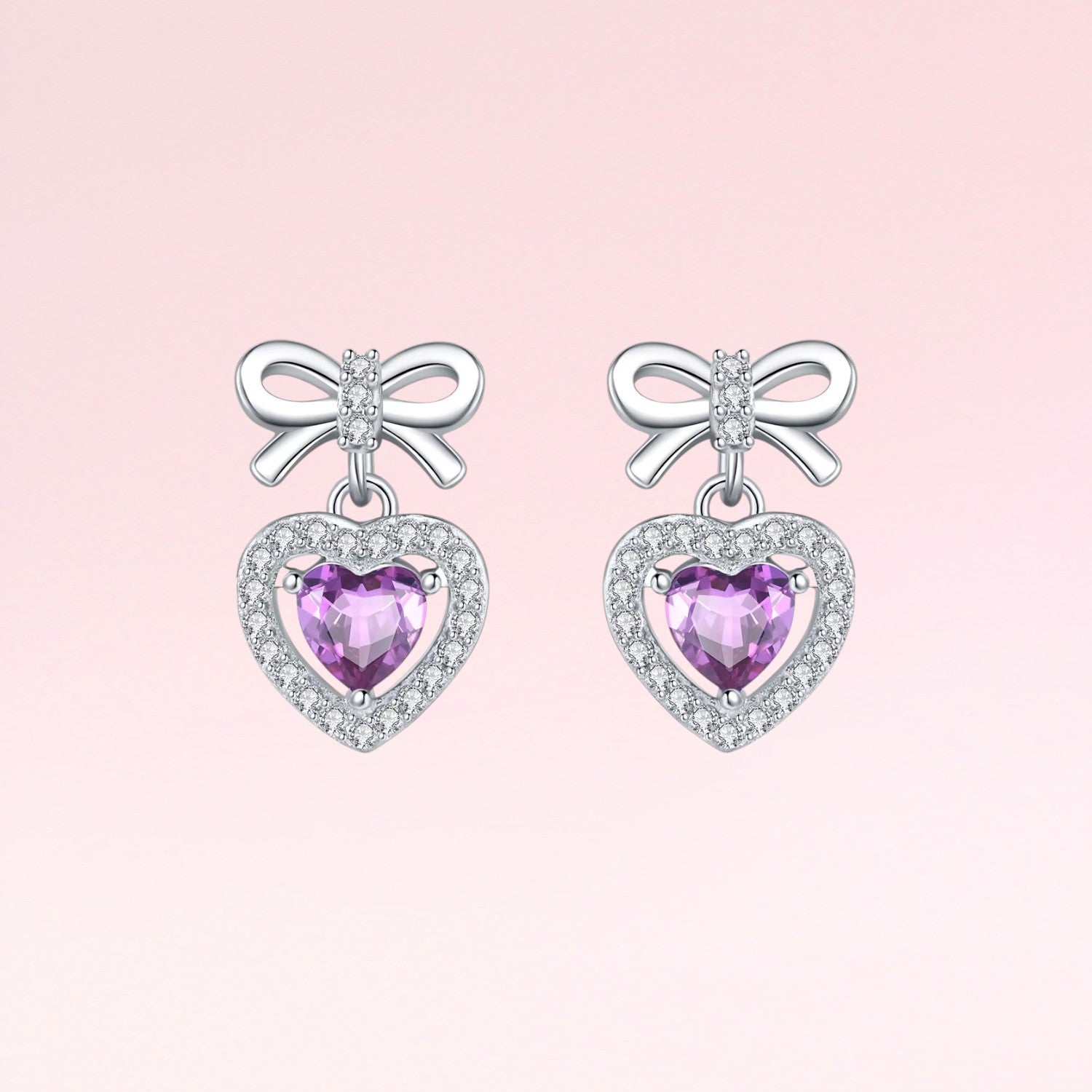 Pair of earrings with heart-shaped purple gemstones and bow designs on a pink background