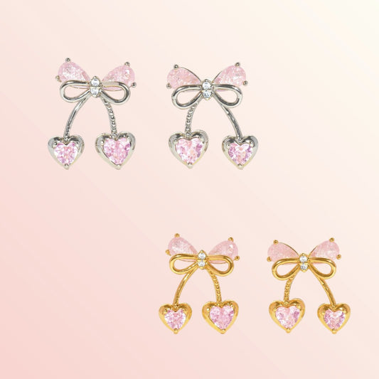 Pair of bow-shaped earrings with pink gemstones on a light pink background