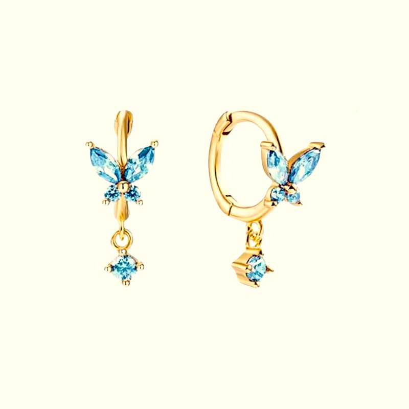 Gold butterfly earrings with blue gemstones on a white background