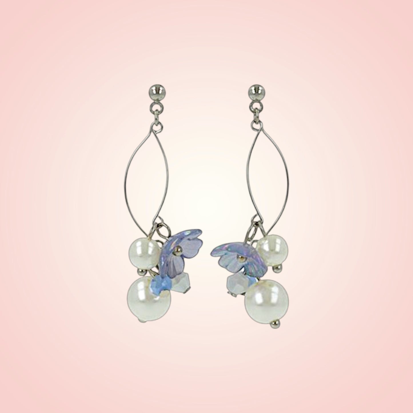 Pair of earrings with floral and pearl designs on a pink gradient background