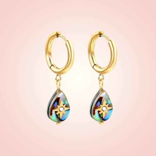 Gold hoop earrings with teardrop-shaped colorful drops on a pink background