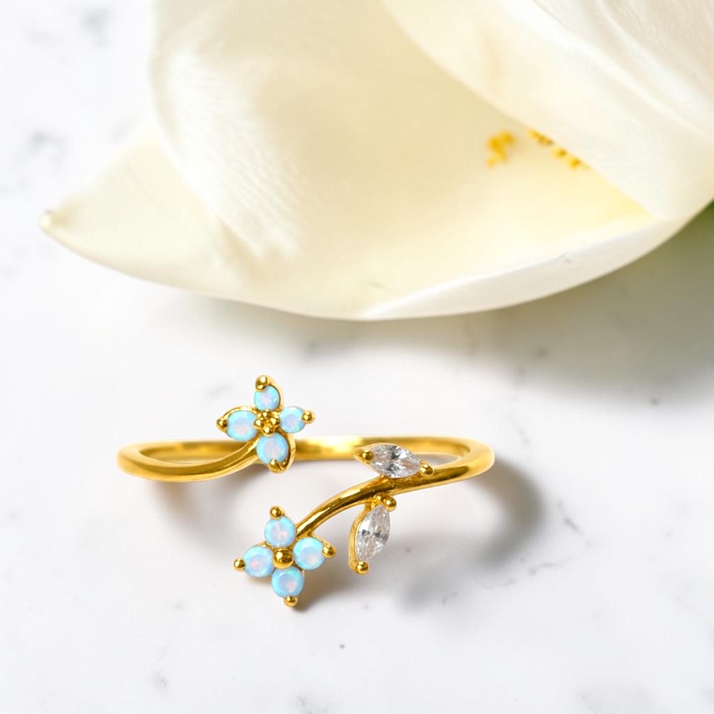 Gold ring with opal stones on a white surface