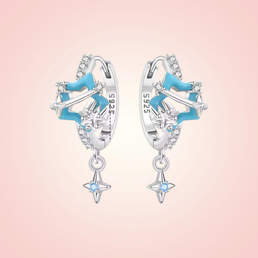 Star-shaped earrings with blue accents on a pink background