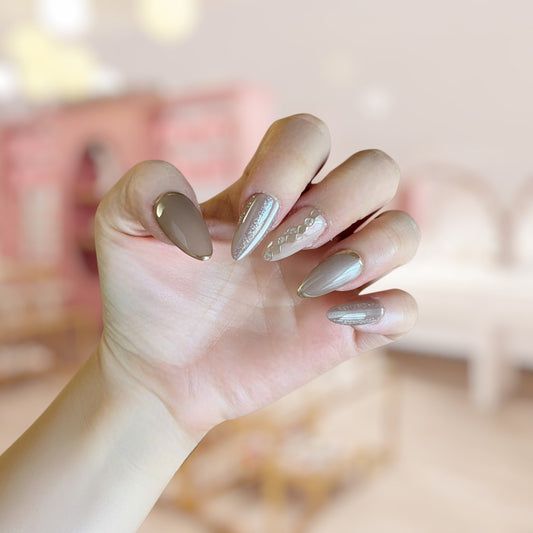 Hand with stylish nail design against a blurred background