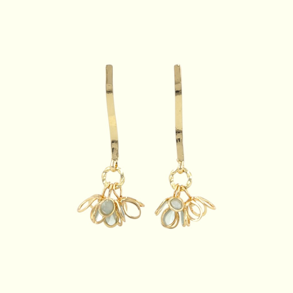 Gold earrings with floral designs on a white background