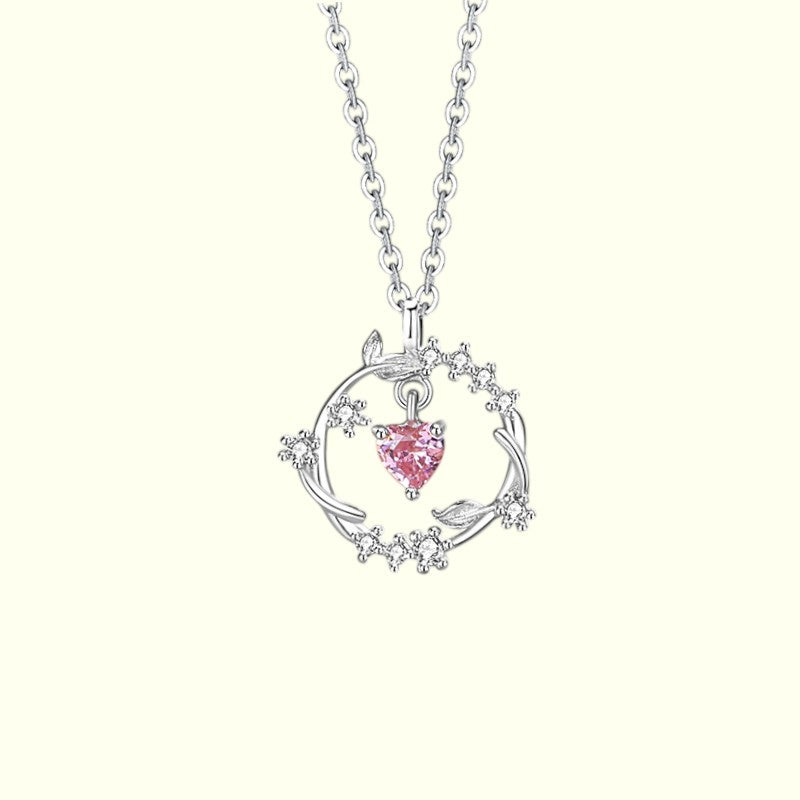 Silver necklace with a pink heart pendant on a white background