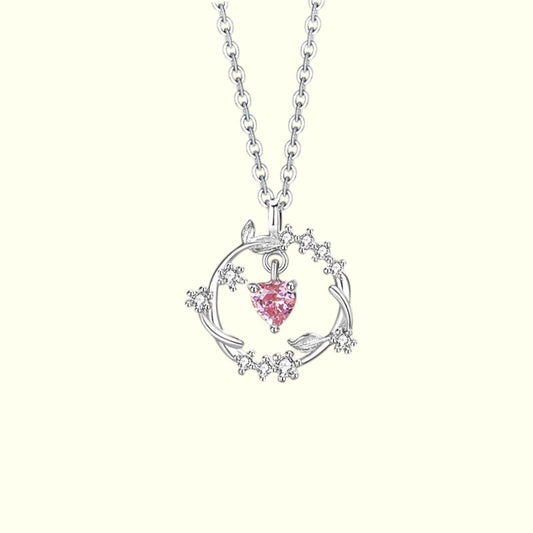 Silver necklace with a pink heart pendant on a white background