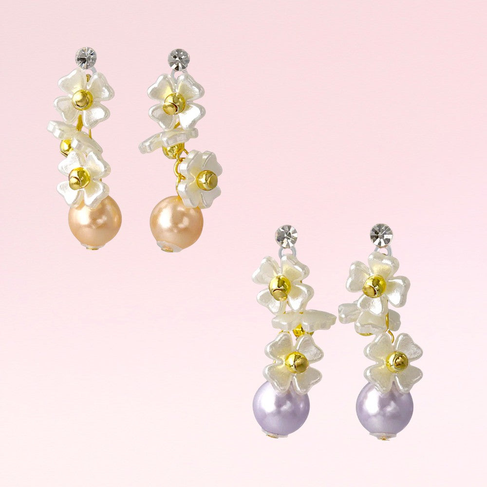 Pair of floral earrings with pearls on a pink background