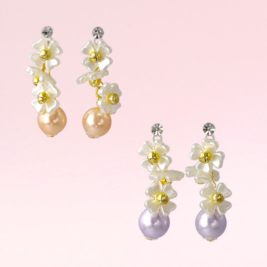 Pair of floral earrings with pearls on a pink background