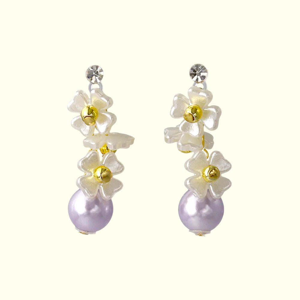 Pair of floral earrings with pearls on a white background