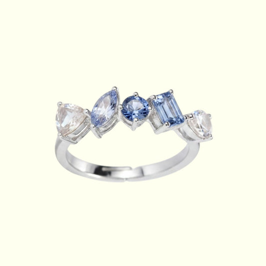 Silver ring with blue and clear gemstones on a white background