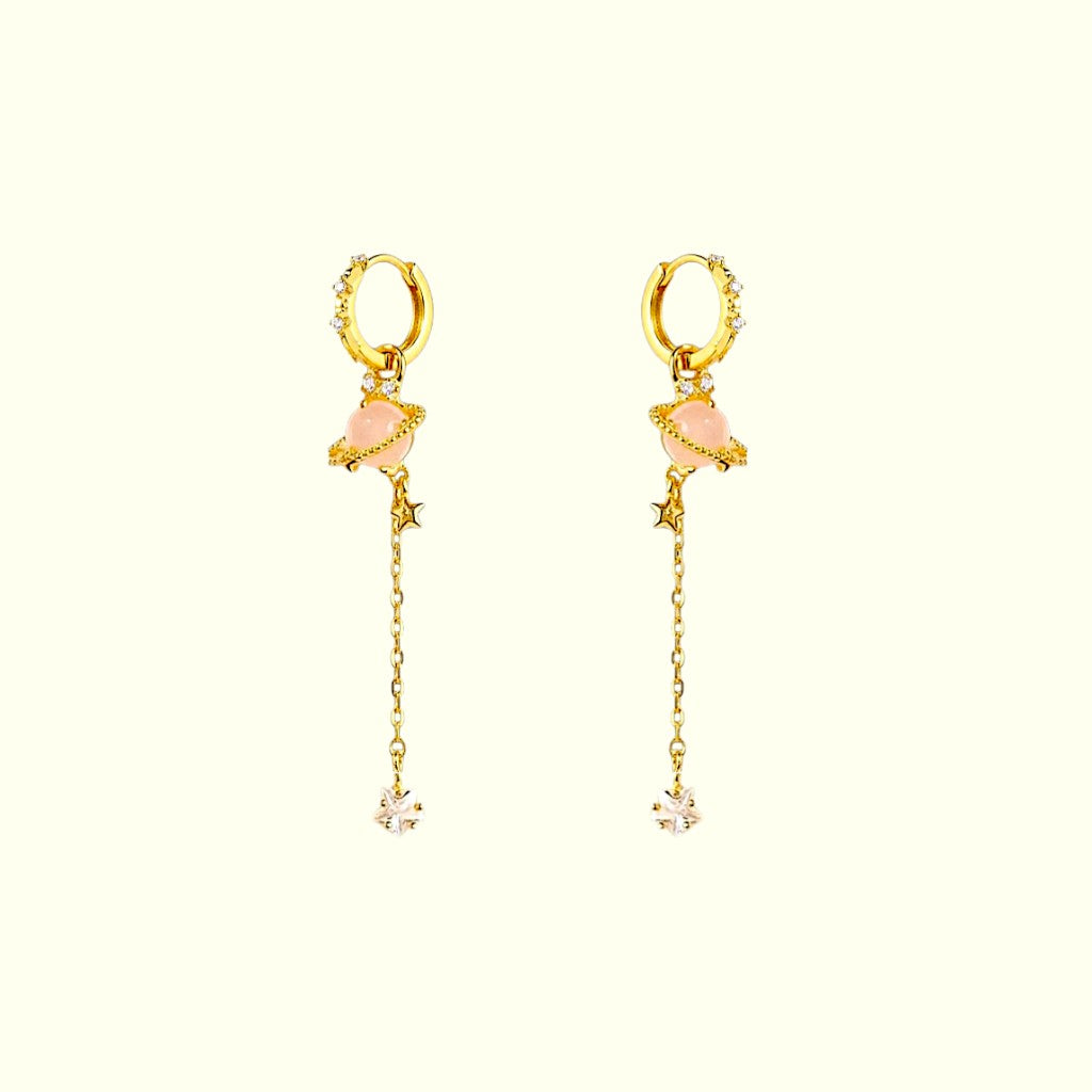 Gold hoop earrings with pink gemstones and chain drops on a white background