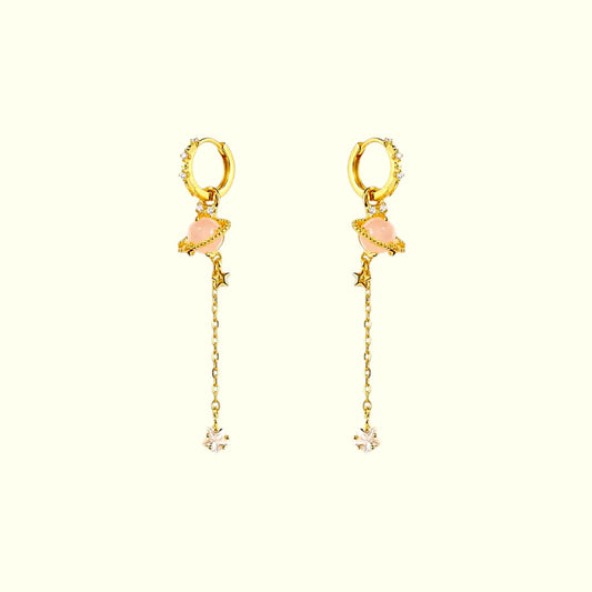 Gold hoop earrings with pink gemstones and chain drops on a white background