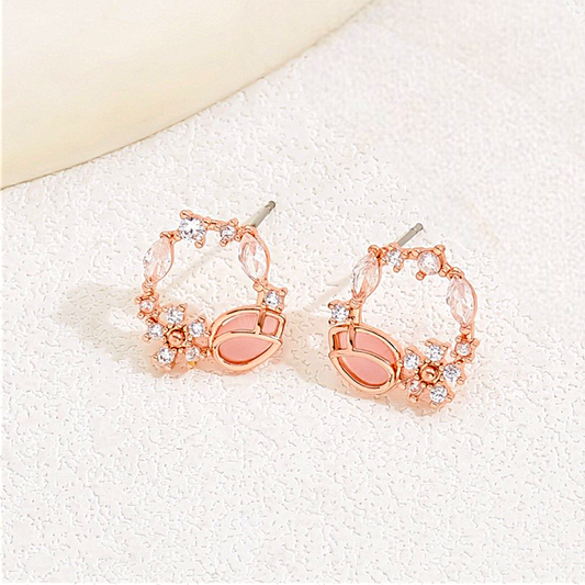 Rose gold hoop earrings with clear stones on a white background