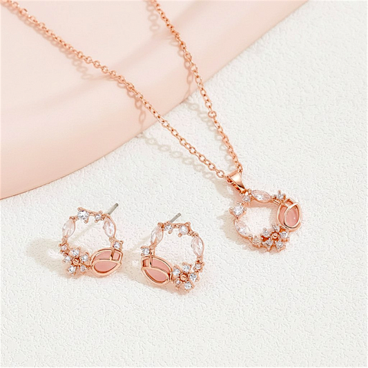 Rose gold jewelry set with necklace and earrings on a soft background
