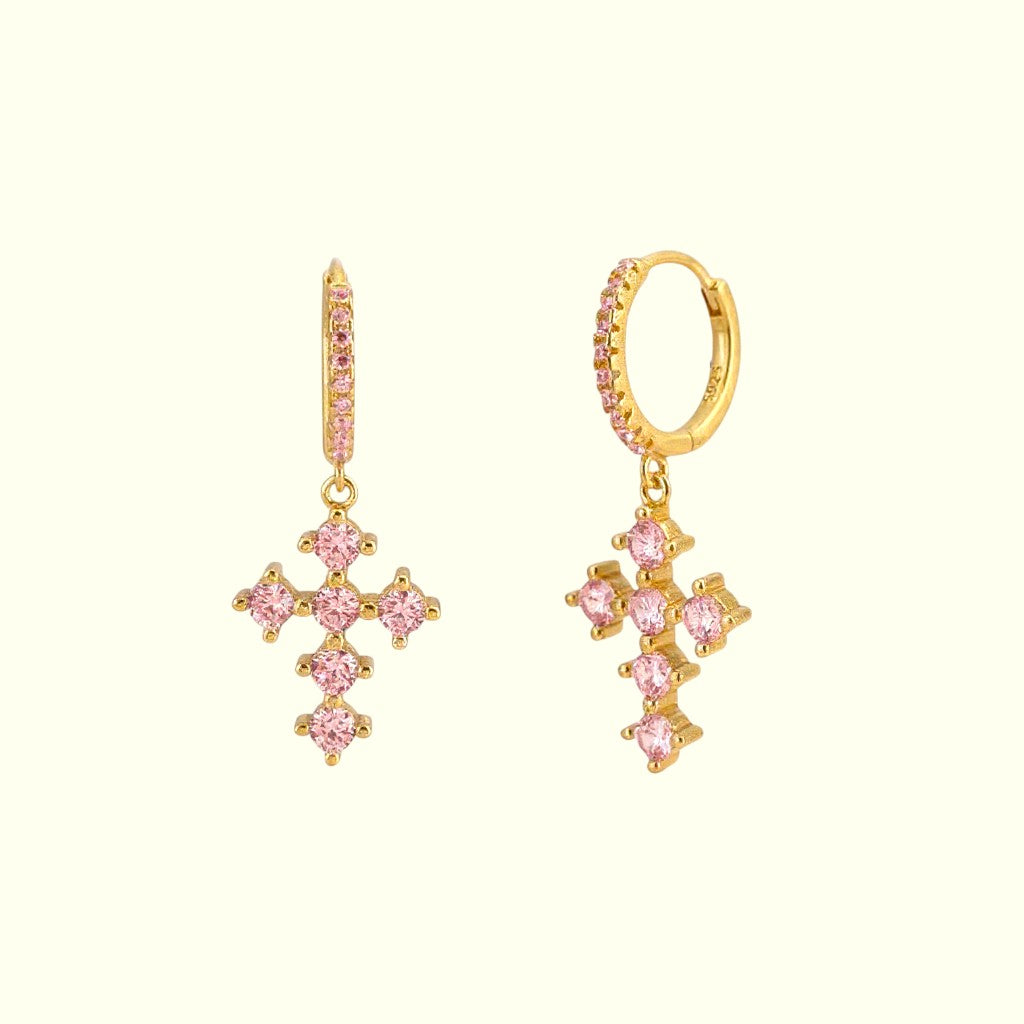 Gold earrings with pink gemstones on a white background
