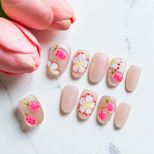 Set of floral nail art designs on a marble surface with pink tulips.