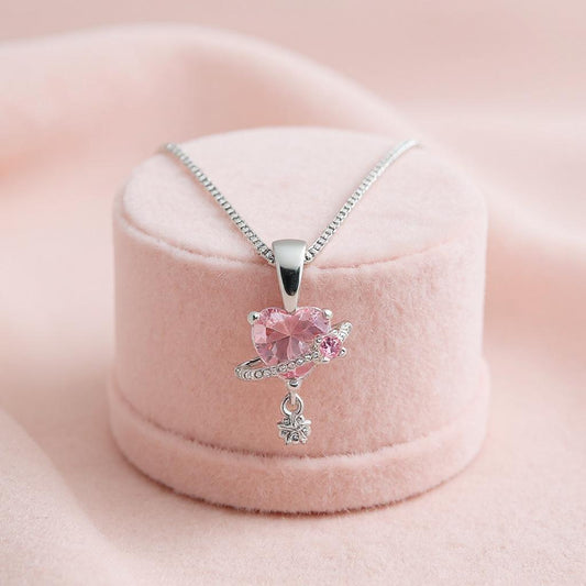 Pink gemstone necklace with silver chain on a pink cushion