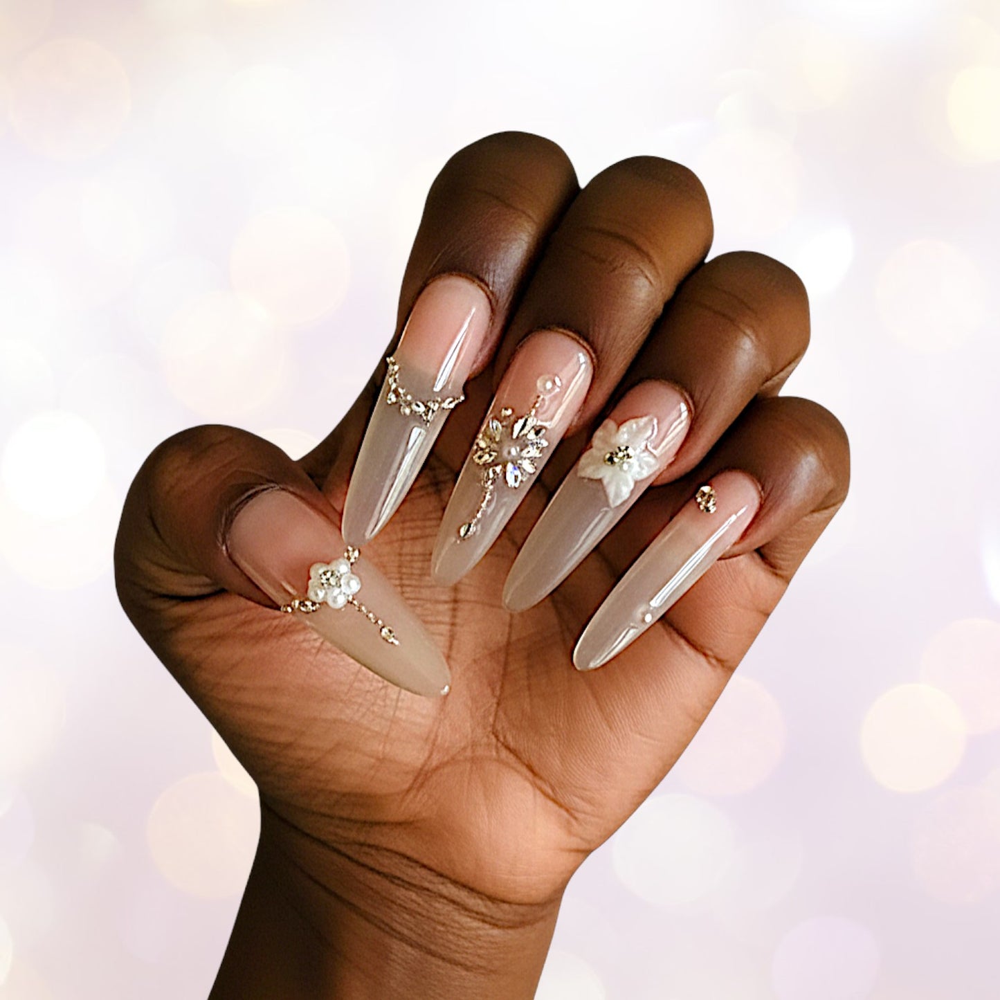 Hand with long, decorated nails on a blurred background