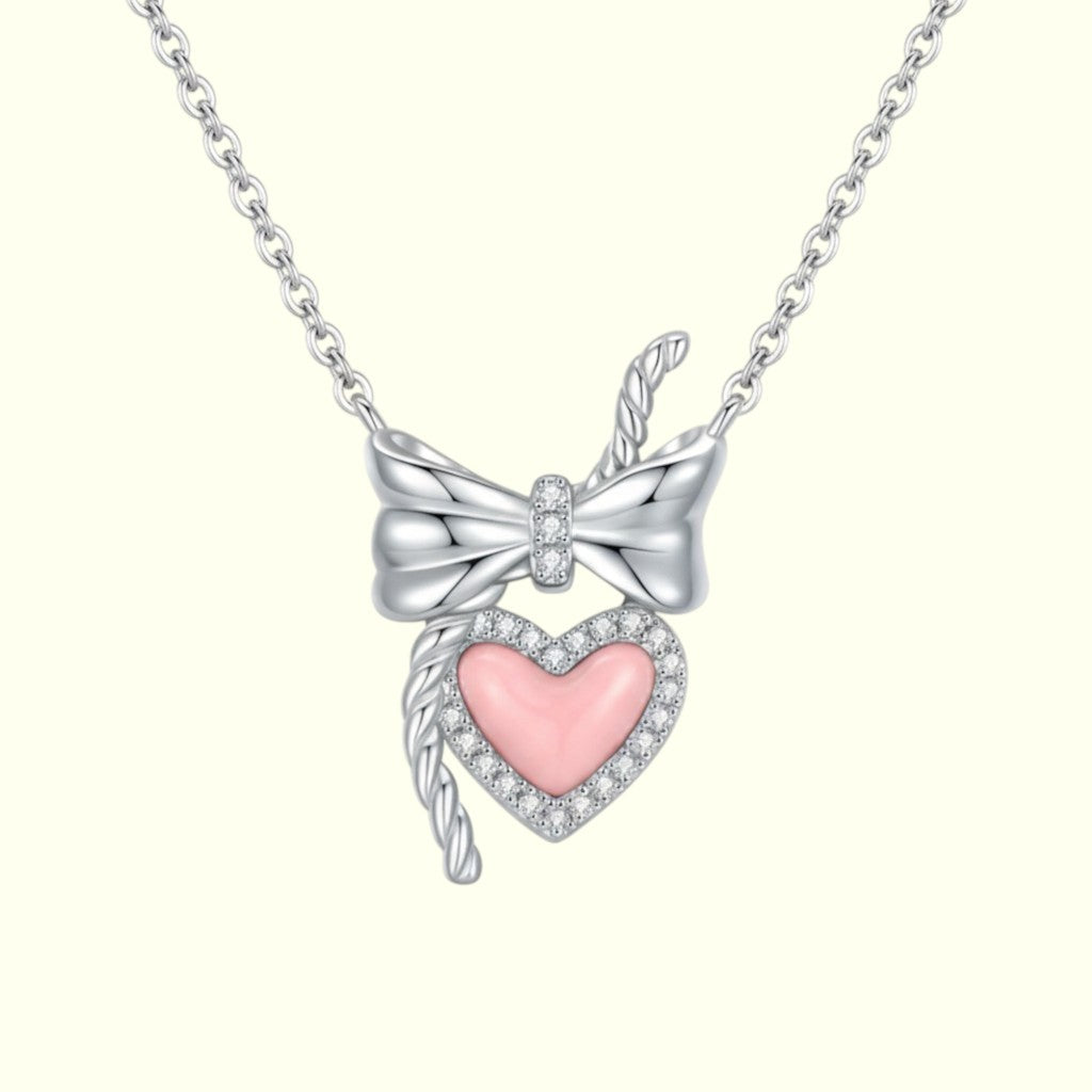 Necklace with a silver bow and pink heart pendant on a white background