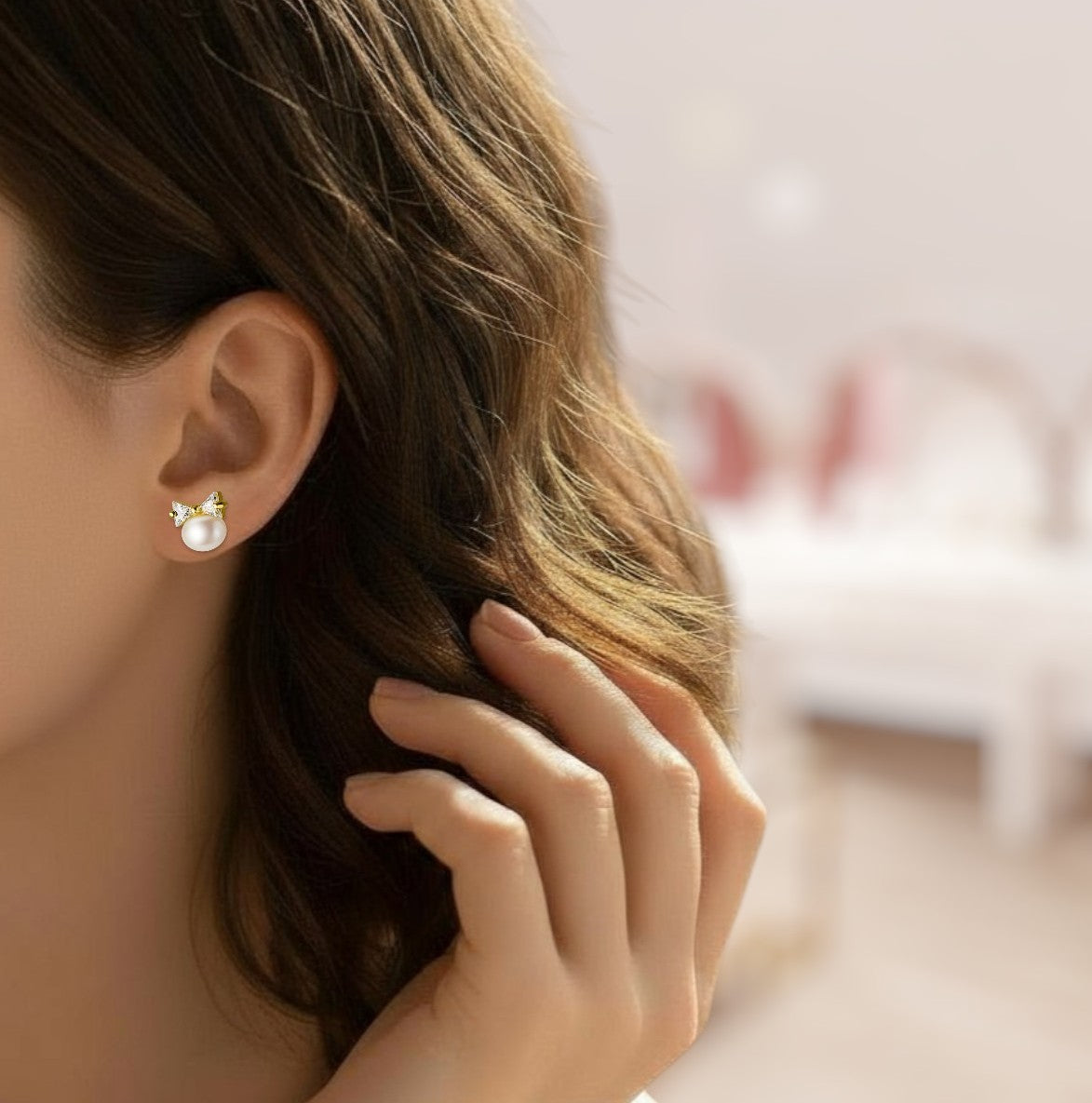 Close-up of a person wearing a pearl earring with a blurred background