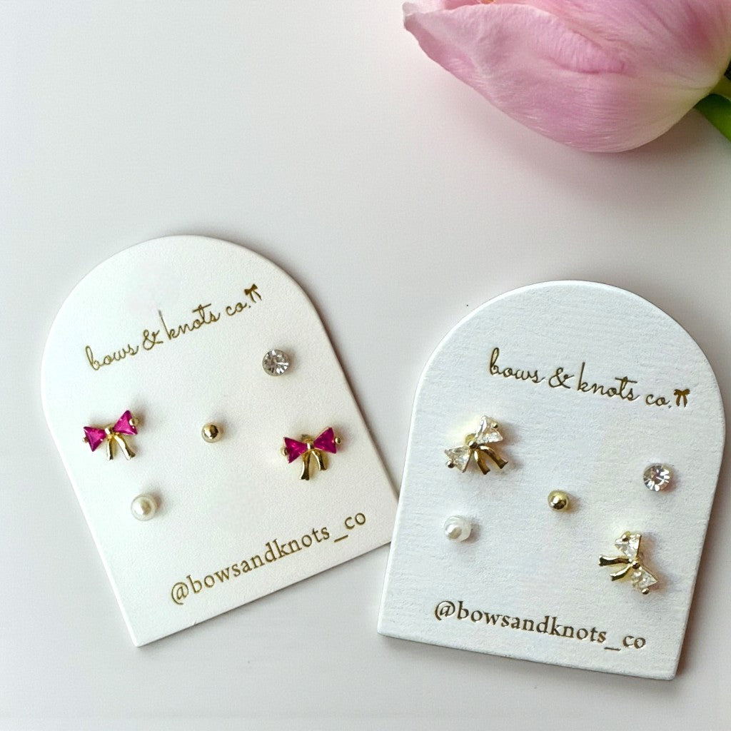 Two heart-shaped earring display cards with earrings on a white background