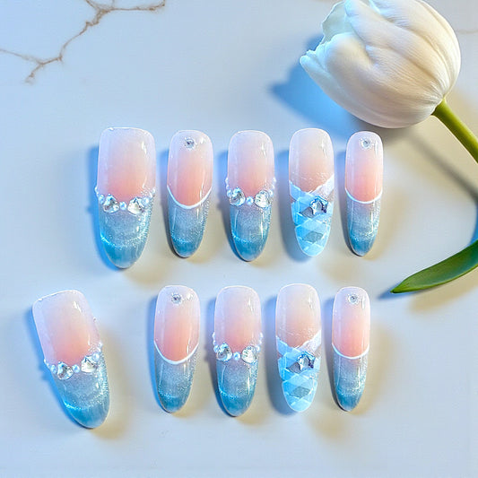 Nail art with gradient design on a white surface with a tulip.