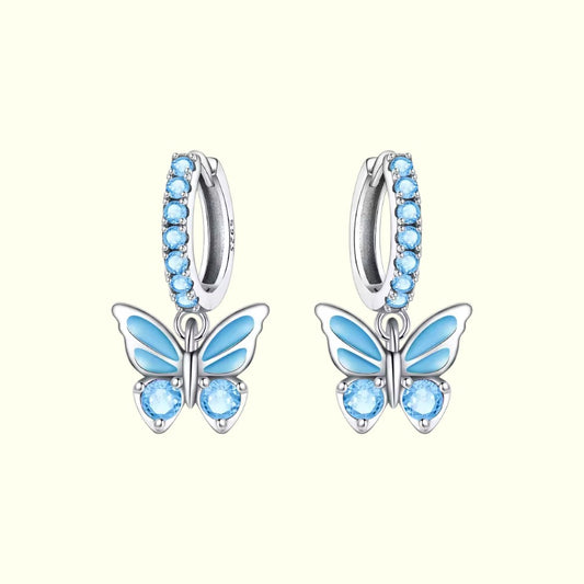 Butterfly earrings with blue gemstones on a white background