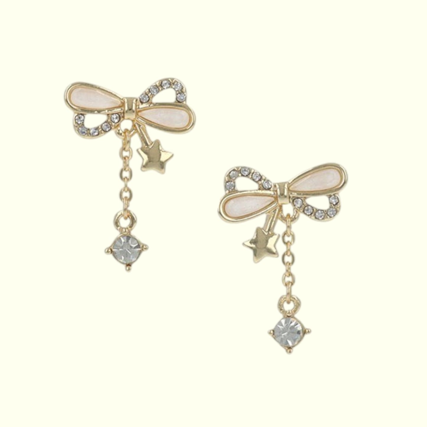 Pair of gold bow-shaped earrings with star and gemstone details on a white background