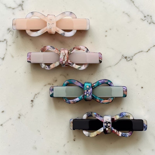Set of four colorful hair clips on a marble surface