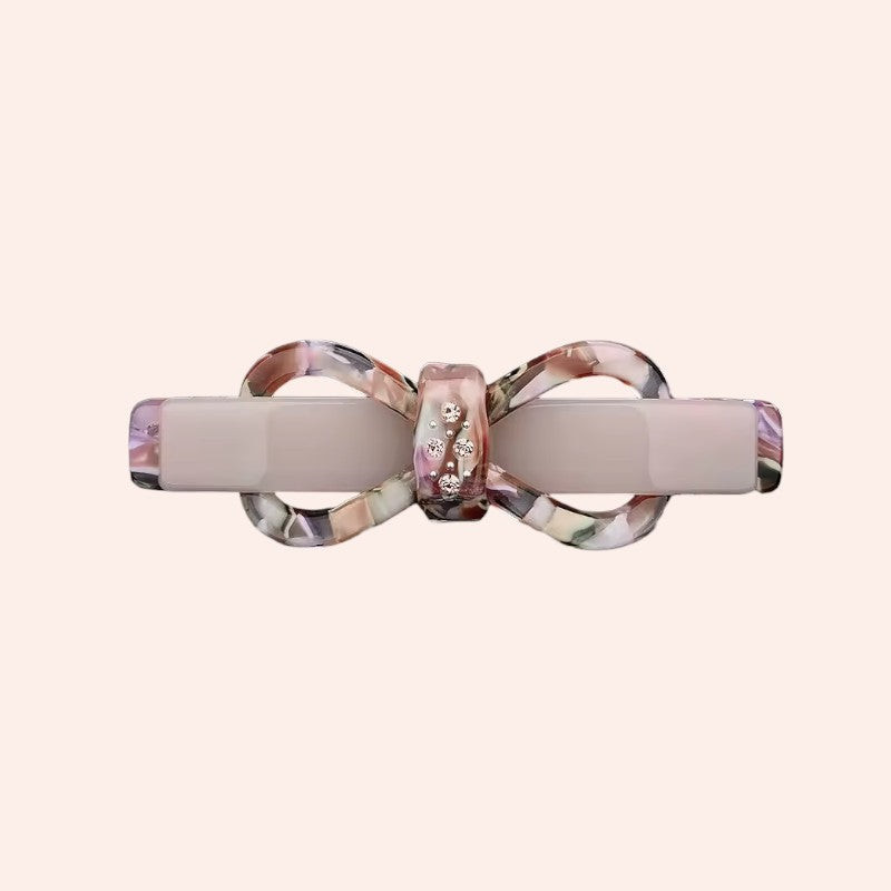 Decorative hair clip with a bow design on a white background